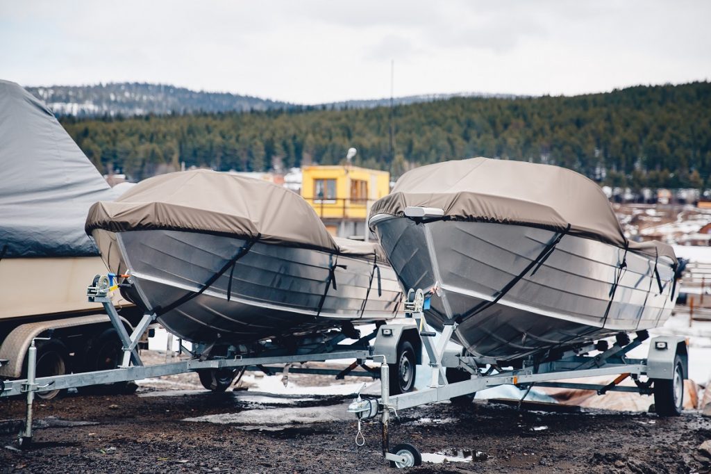 Covered boats on steel pontoon trailers