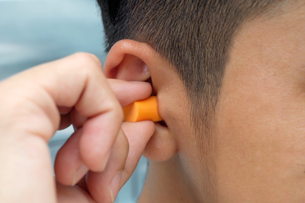 Man putting a protective ear plug