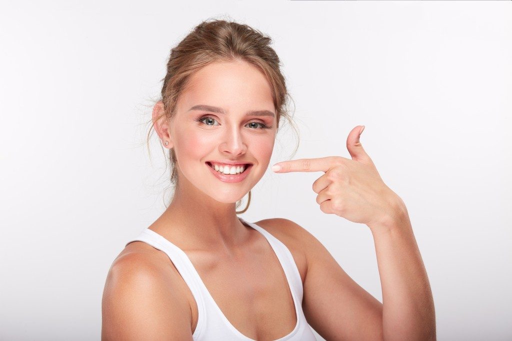 Woman pointing at her white teeth