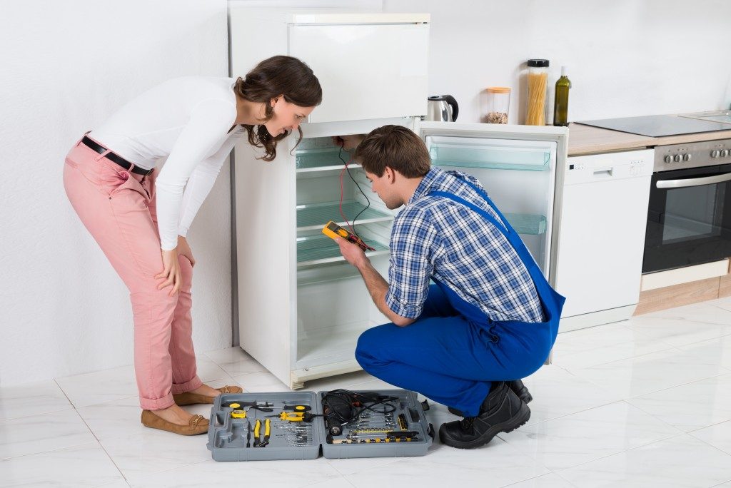 Homeowner and technician looking at the refrigerator