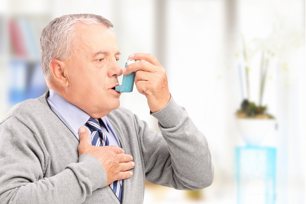 man holding inhaler at home