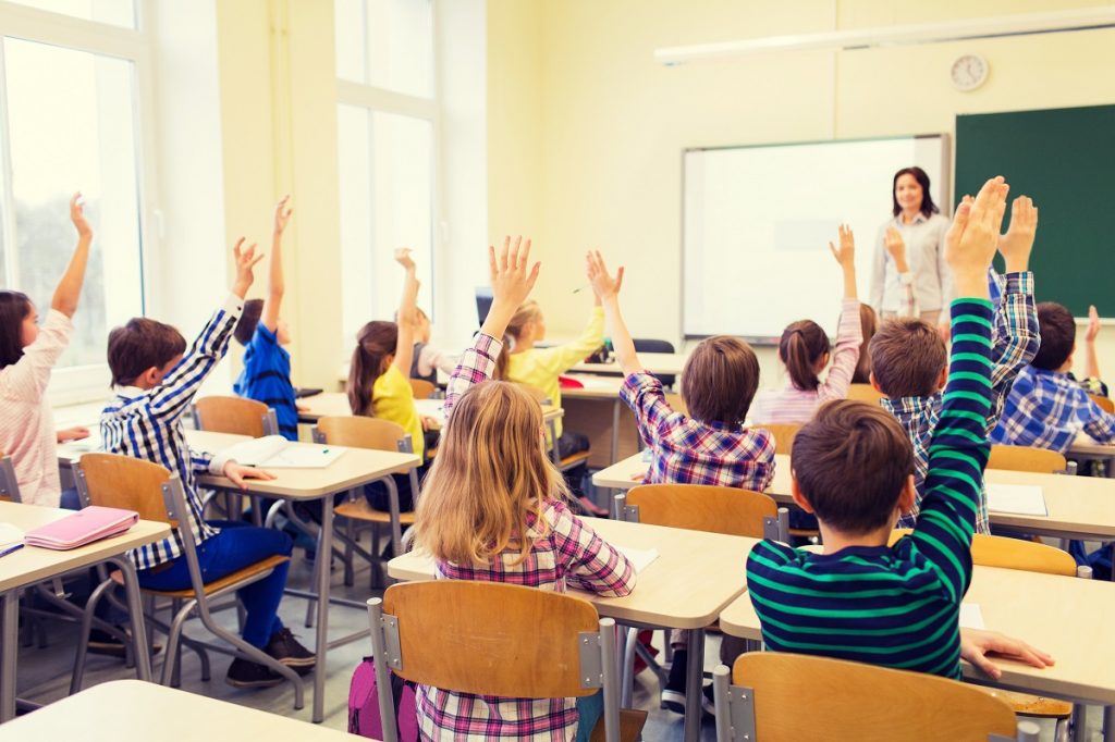 Kids raising their hands in class