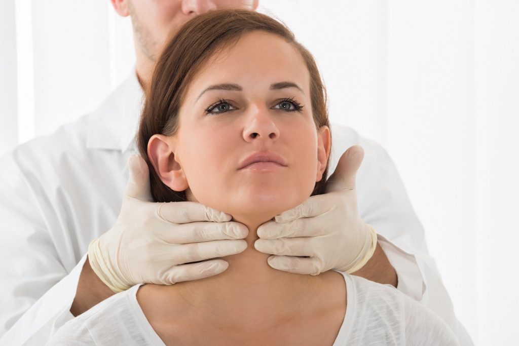 doctor checking the neck of a woman