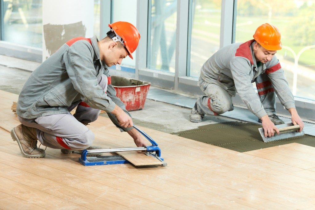 construction workers installing floor tiles