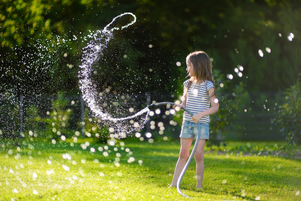 kid playing with water hose