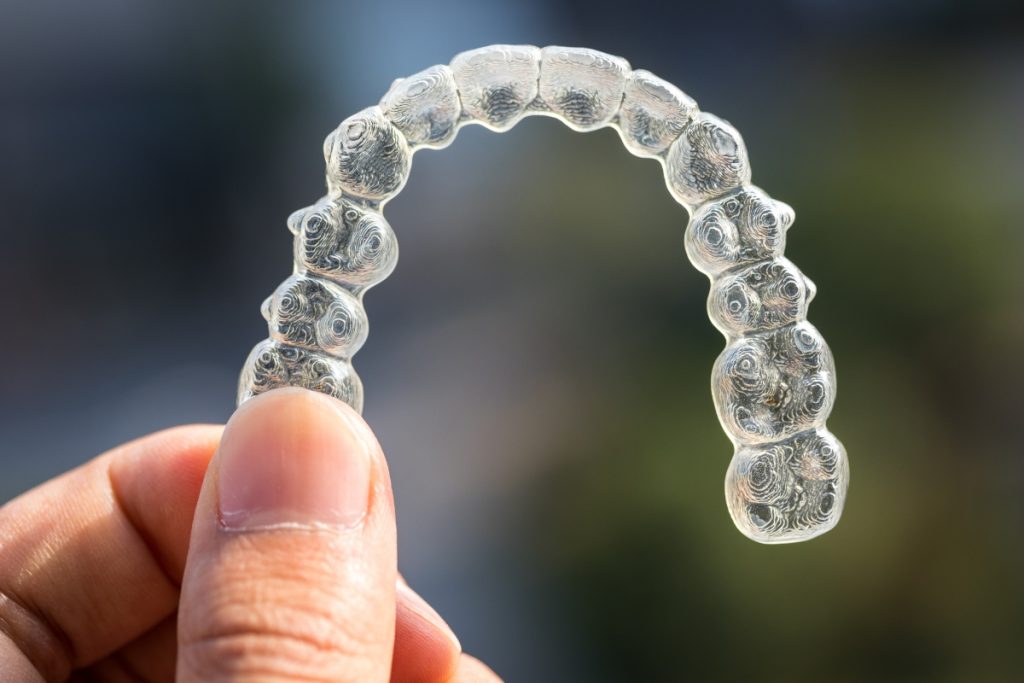 person holding transparent retainers