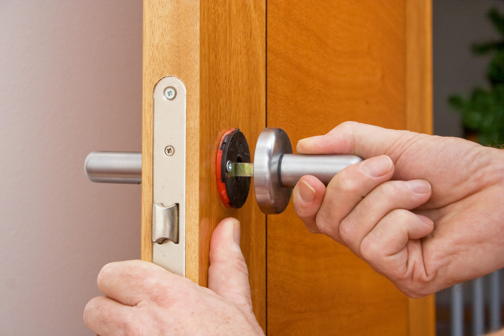 Technician installing a lock system on the door of a home.