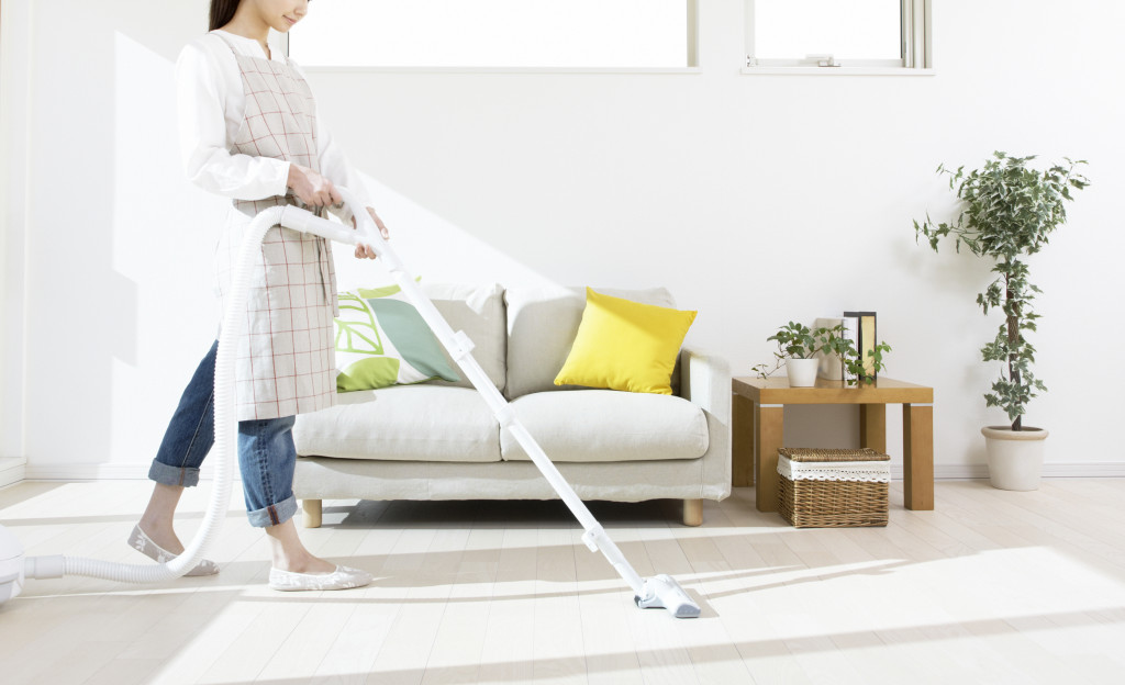Woman vacuums living room floor