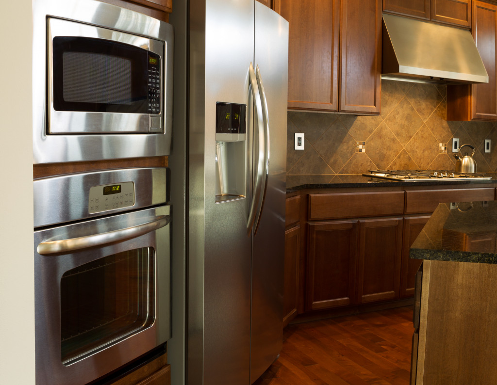 Steel microwave, oven, and refrigerator in a modern kitchen
