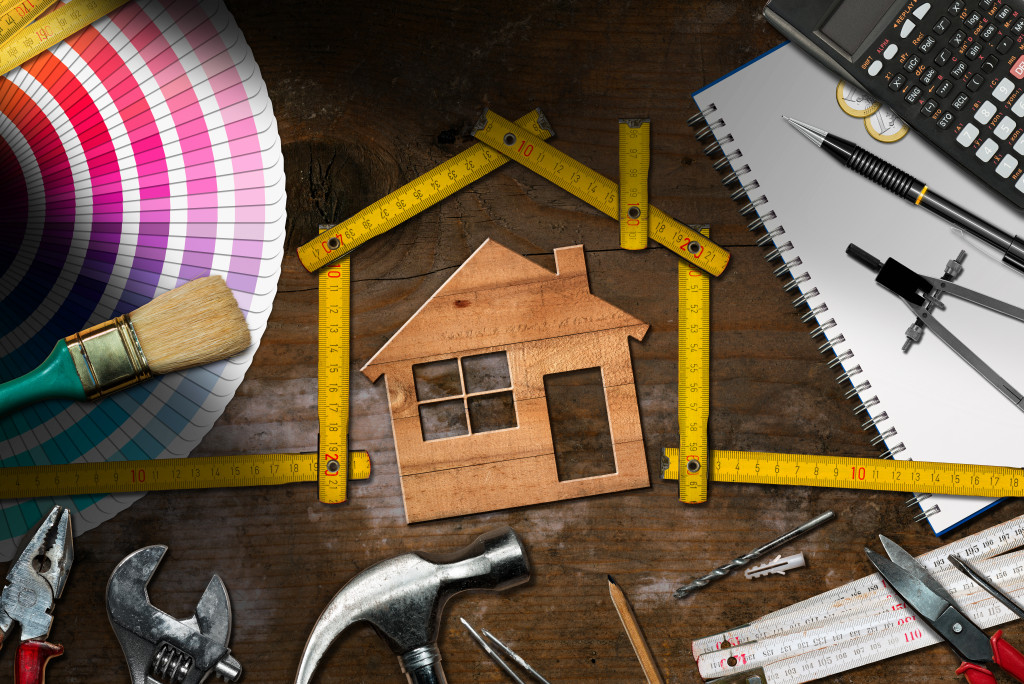 tools for home construction with wooden house on the middle