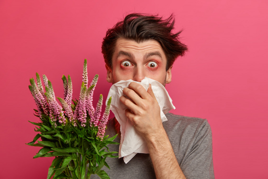 Allergic man holding plants